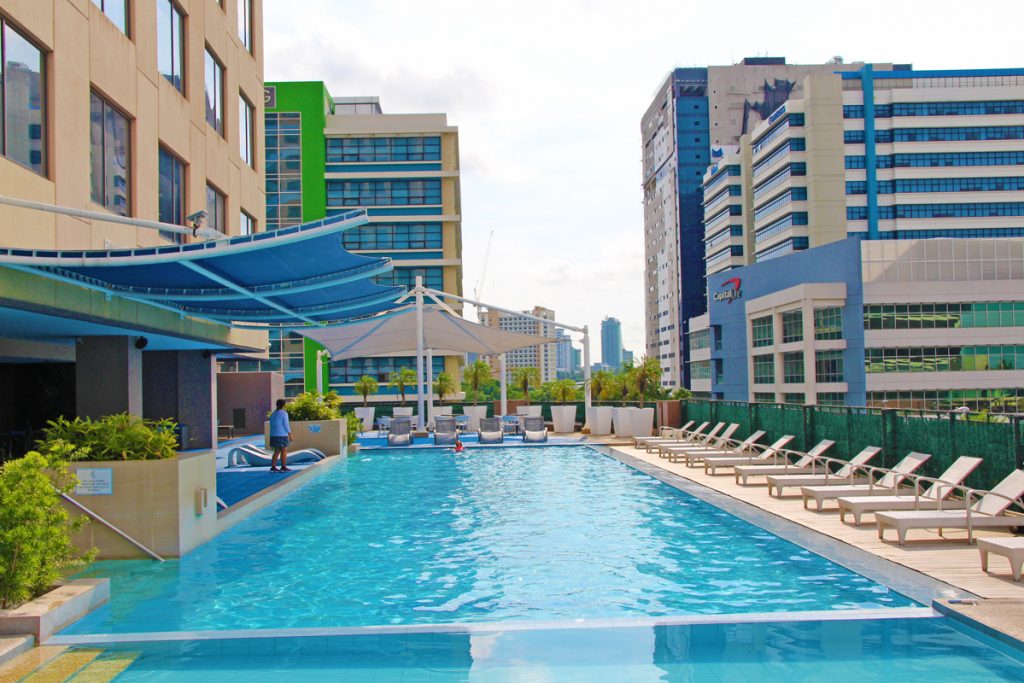swimming pool at bellevue hotel manila with buildings infinity